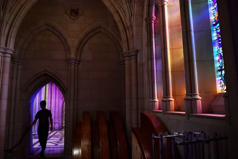 A visitor walks through a corridor of Washington National Cathedral. (Matt McClain/The Washington Post)