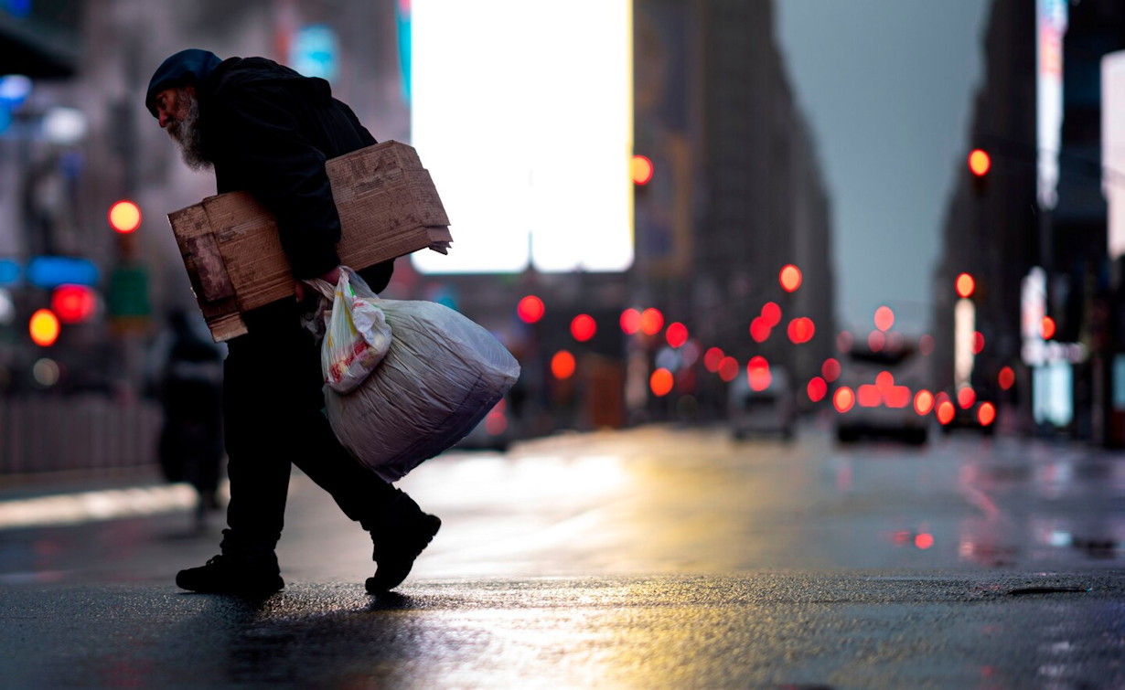 A homeless man carries cardboard as he crosses the almost deserted Times Square in New York on Monday.
